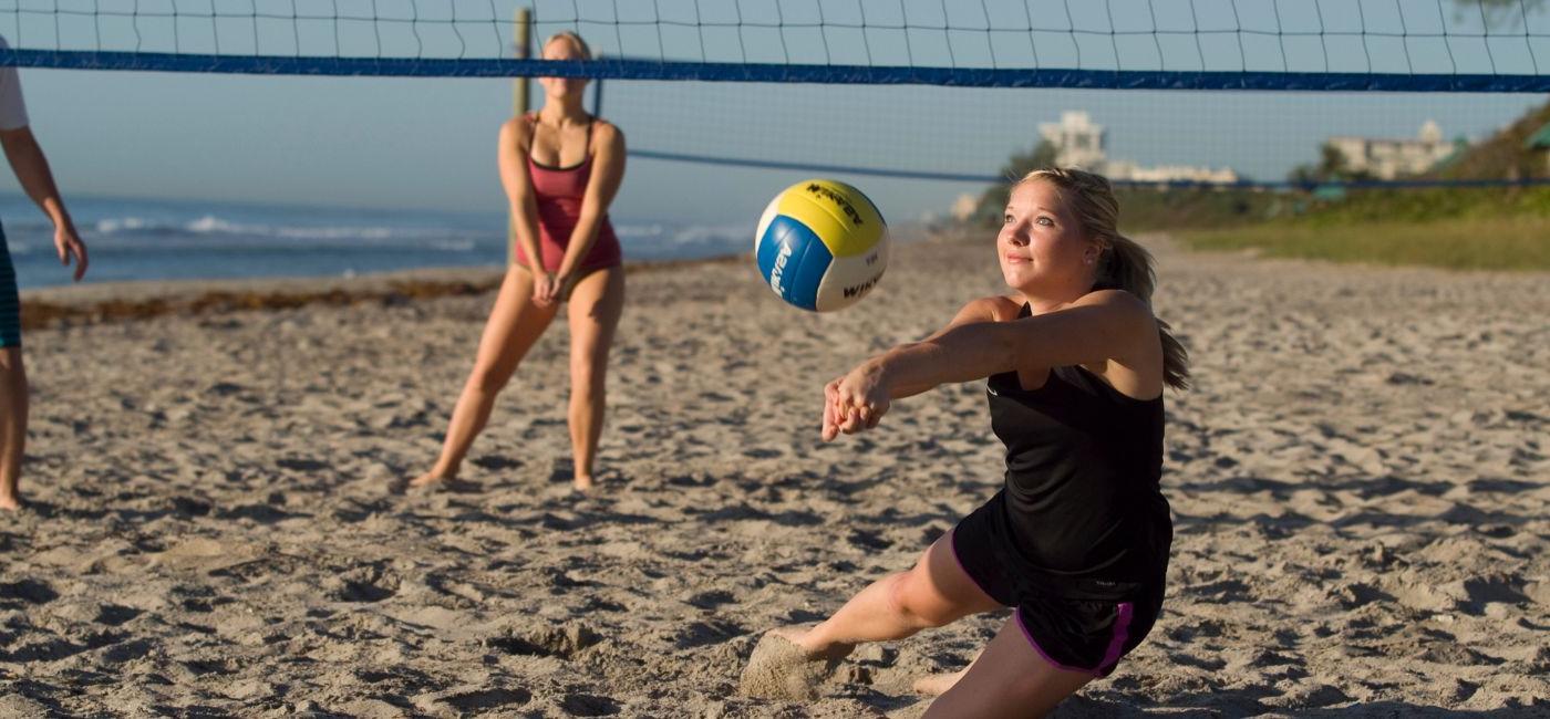 students playing volleyball on the beach